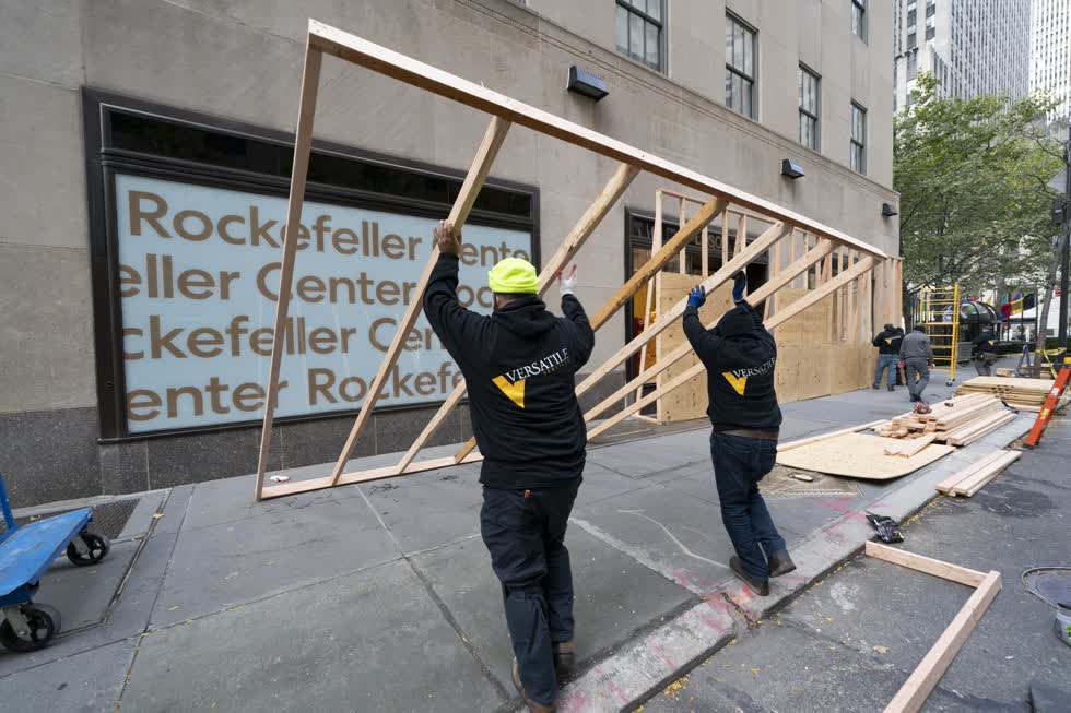 Các công nhân dựng một bức tường ván ép vào ngày 2/11 để bảo vệ một cửa hàng LEGO ở Trung tâm Rockefeller ở New York. Ảnh: AP