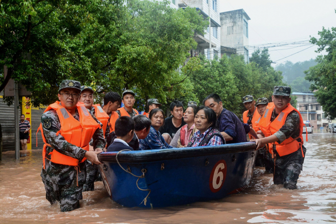 Người dân được lực lượng cứu hộ đưa ra khỏi vùng ngập ở Trùng Khánh. Ảnh: NYT.