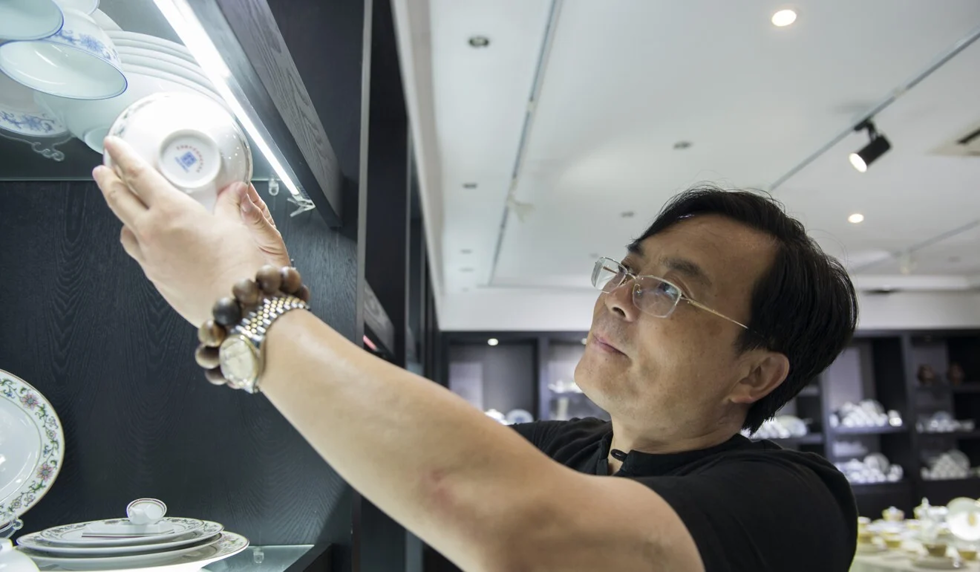 Chủ nhà máy Xiong Jianjun cho biết, cách để biết một món đồ sứ có chất lượng hay không là cầm nó lên ánh sáng và kiểm tra độ trong mờ. Ảnh: Zigor Aldama