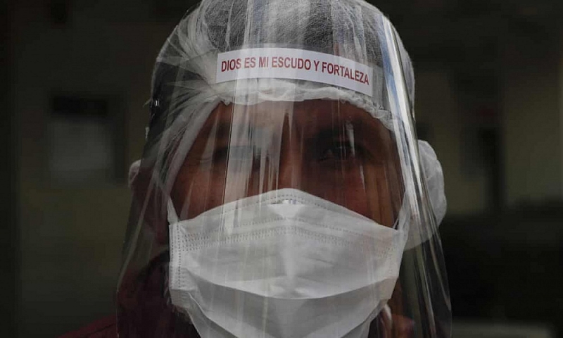 Một nhân viên y tế Bolivia đeo khẩu trang và mặt nạ chống Covid-19 trong khi làm nhiệm vụ. Ảnh: AP.