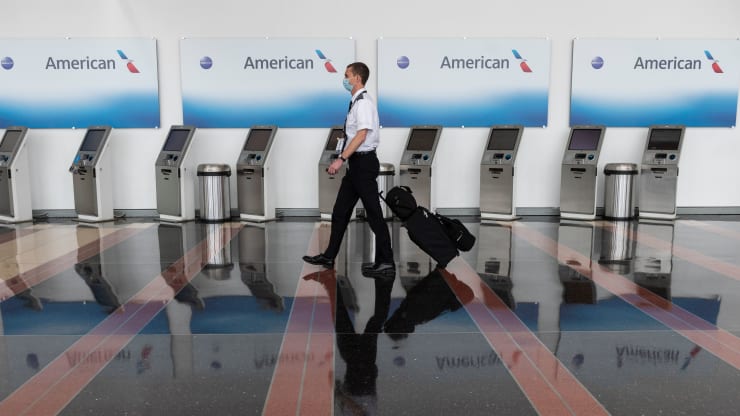   Một nhân viên hàng không đi ngang qua các nhà ga làm thủ tục của American Airlines tại Sân bay Quốc gia Ronald Reagan Washington ở Arlingtonvào ngày 12/5.  