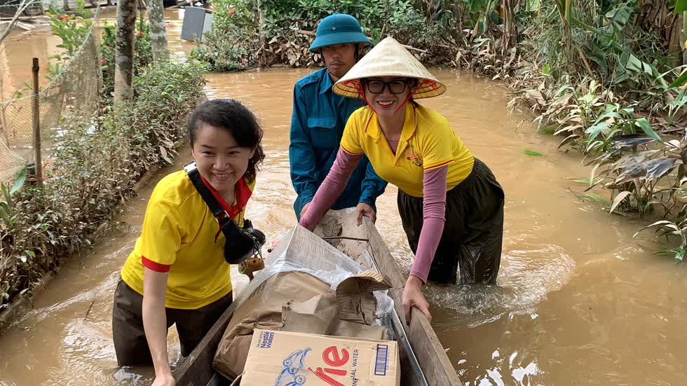 Người mẫu Trang Khàn (bên phải) vận chuyển đồ ăn và nước uống đến cho bà con. Ảnh: Facebook nhân vật