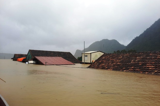 Lũ lên nhanh, bất ngờ khiến người Quảng Bình trở tay không kịp, hàng nghìn ngôi nhà ngập trong biển nước. Ảnh: Thanh Niên