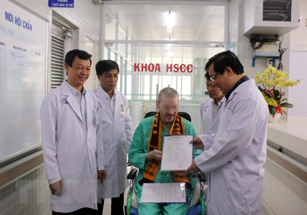 Lãnh đạo Bộ Y tế trao giấy chứng nhận xuất viện và chứng nhận âm tính với virus SARS-CoV-2 cho bệnh nhân 91. Ảnh: TTXVN.