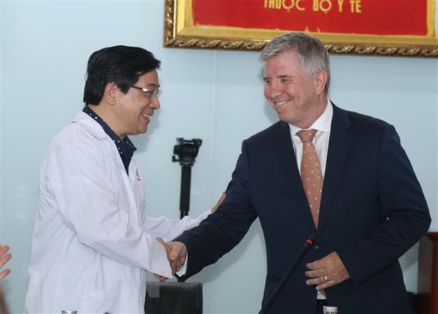 Ông Ian Gibbons, Tổng Lãnh sự Anh tại Thành phố Hồ Chí Minh cảm ơn ông Lương Ngọc Khuê, Cục trưởng Cục Quản lý Khám chữa bệnh - Bộ Y tế. Ảnh: TTXVN.
