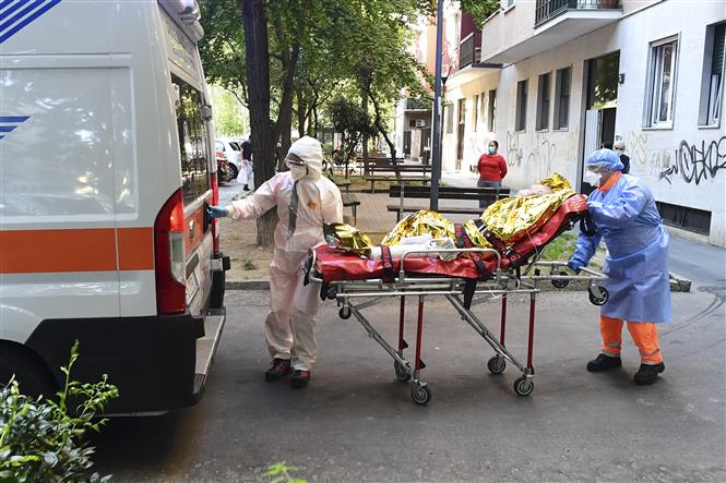 Chuyển bệnh nhân COVID-19 lên xe cứu thương tại Milan, Italy. Ảnh: AFP/ TTXVN