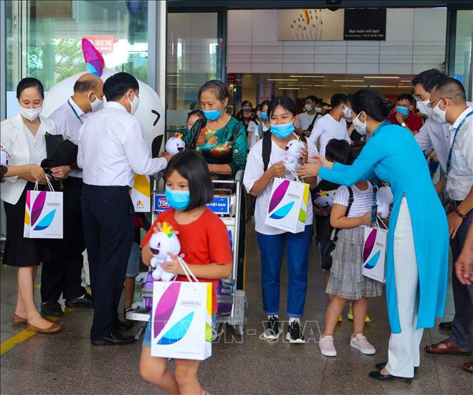 Tại Sân bay quốc tế Đà Nẵng, Đại diện Sở Du lịch Đà Năng tặng quà cho đoàn du khách đầu tiên trở lại du lịch thành phố sau dịch COVID-19. Ảnh: TTXVN.