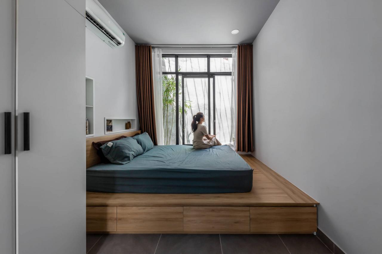 Phòng ngủ đơn giản, gọn gàng với gam màu trắng chủ đạo. Không gian này cũng thoáng đãng nhờ kết nối trực tiếp với 2 khoảng sân vườn ở giữa và sau nhà. 