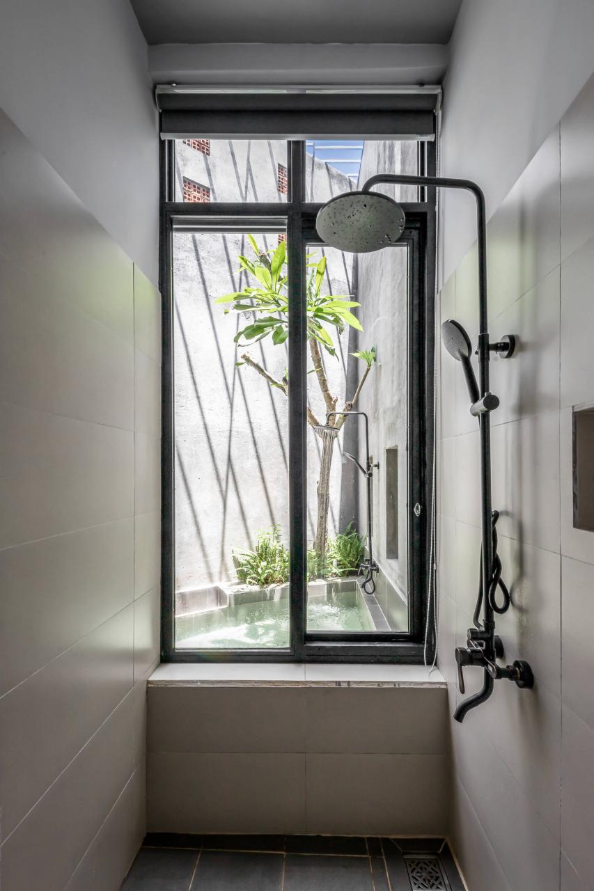 Phòng tắm nhỏ gọn, kết nối trực tiếp với tiểu cảnh hồ nước ở sân vườn phía sau nhà. 
