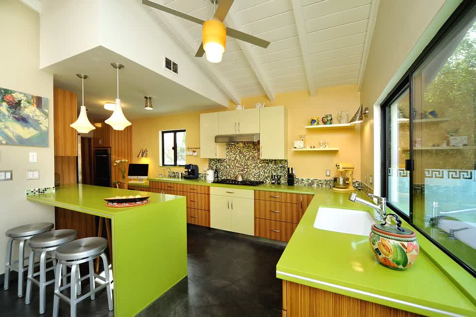   Phòng bếp phong cách mid-century tuyệt đẹp với bức tường tạo điểm nhấn màu vàng và mặt bàn màu xanh lá cây bắt mắt.  