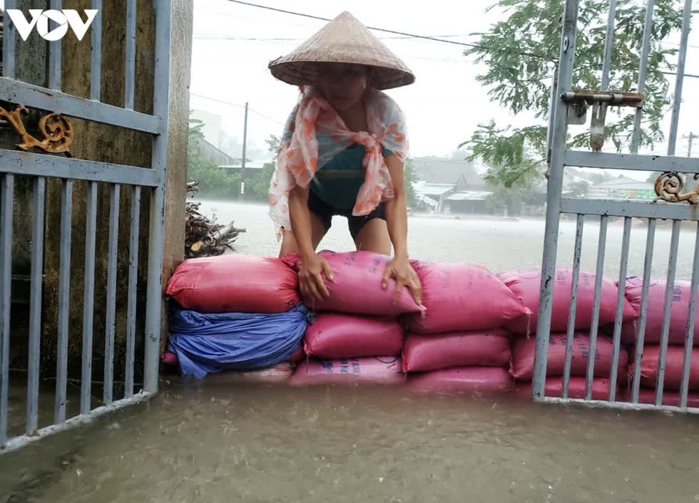 Người dân ở khu dân cư Chợ Lò, xã Tam Thái, huyện Phú Ninh, tỉnh Quảng Nam dùng bao tải kè chắn ngăn nước tràn vào nhà. Ảnh: VOV