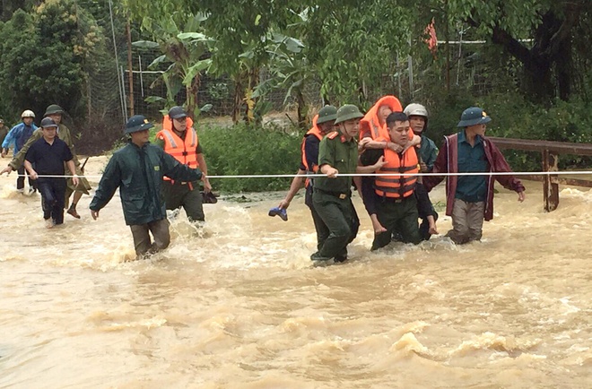 Lực lượng chức năng hỗ trợ người dân di dời khỏi khu vực ngập lụt. Ảnh: Zing