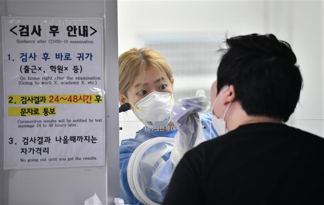   Nhân viên y tế lấy mẫu xét nghiệm COVID-19 cho người dân tại Seoul, Hàn Quốc ngày 18/8/2020. Ảnh: AFP/TTXVN.  