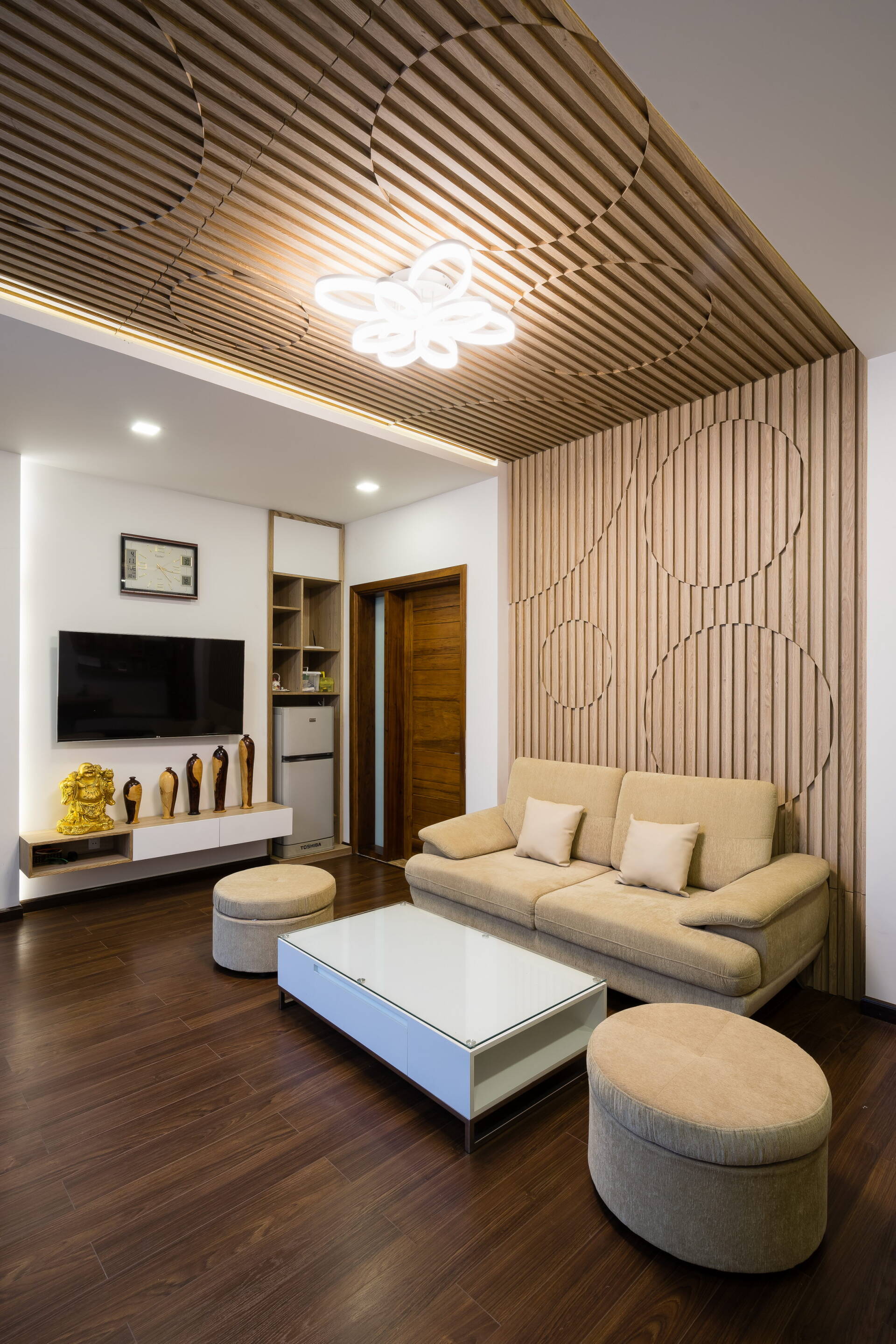 Phòng sinh hoạt chung ở tầng trên với trần và tường bằng gỗ có hoa văn ấn tượng, tạo điểm nhấn cho không gian. 