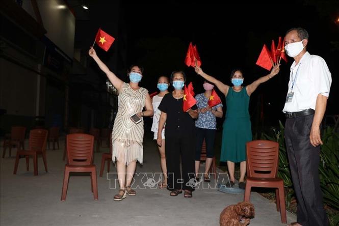  Người dân trong khu phố Ngô Quyền thức chung vui giờ phút dỡ bỏ cách ly y tế. Ảnh: TTXVN