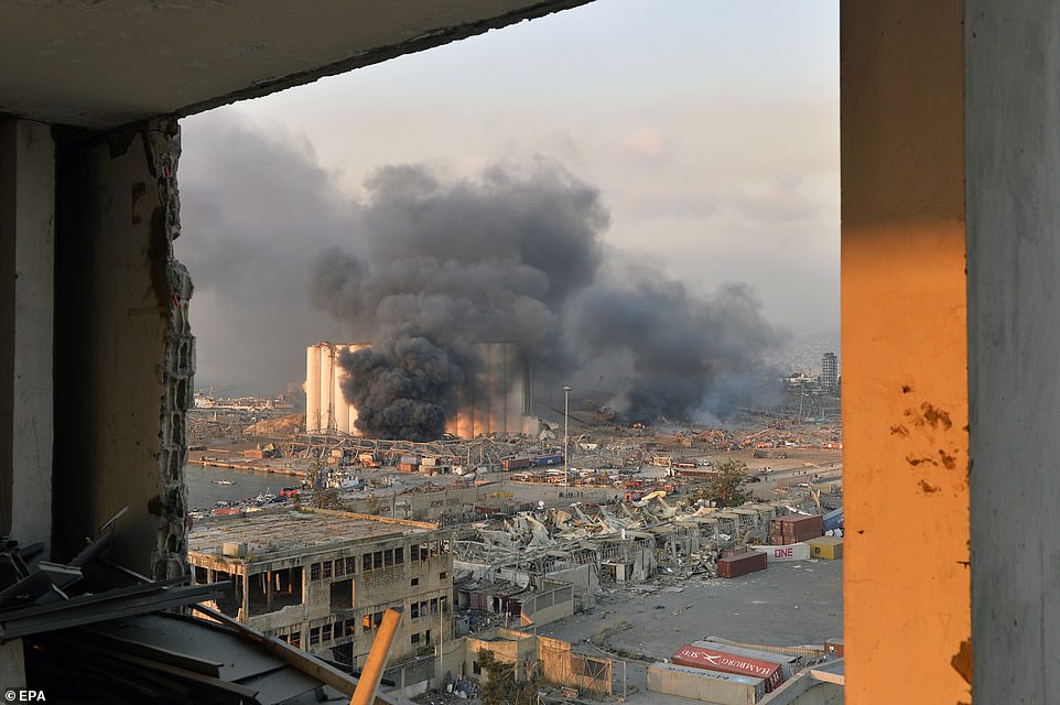 Khói bay từ khu vực bến cảng với thiệt hại và mảnh vụn sau một vụ nổ lớn làm rung chuyển bến cảng Beirut.
