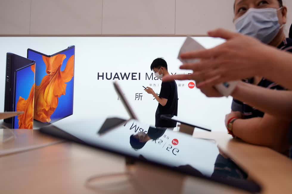 Người dân đeo khẩu trang tại cửa hàng của Huawei, khi họ chính thức khai trương tại Thượng Hải sau dịch COVID-19. Ảnh: Reuters.
