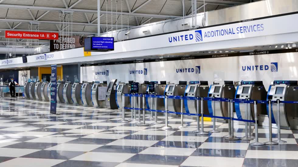 các dãy quầy làm thủ tục của United Airlines tại Sân bay Quốc tế O'Hare ở Chicago không có người sử dụng giữa đại dịch COVID-19. Ảnh: AP.
