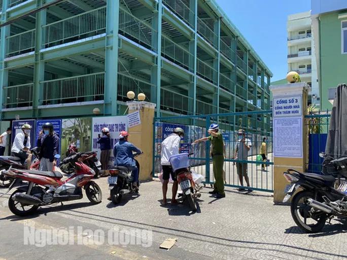 Lực lượng công an hướng dẫn người dân không ra vào Bệnh viện Đà Nẵng trước giờ cách ly toàn bộ bệnh viện. Ảnh: NLĐO.