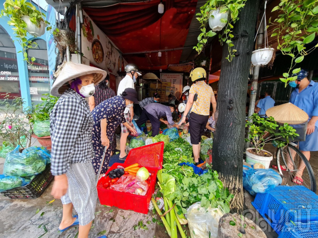 Người dân tranh thủ đi mua lương thực từ sớm để tránh giờ giãn cách xã hội, ảnh chụp lúc hơn 5 giờ sáng tại chợ Nghĩa Tân.
