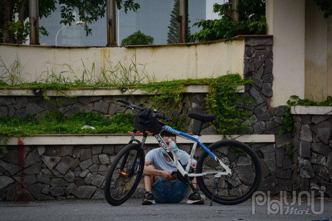 Anh thanh niên này đạp xe từ mờ sáng đến cổng công viên Cầu Giấy ngồi nghỉ ngơi.