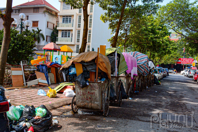 Ở phía trong ngõ 141 Nguyễn Khang, xe rác nào cũng đầy kín không thể chất thêm, rác để tràn cả ra lòng đường.