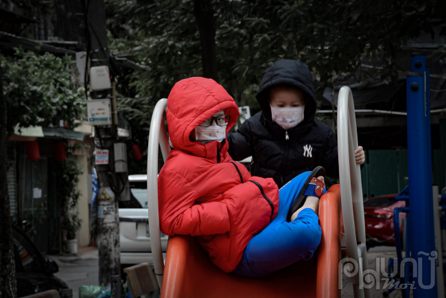 Trẻ em được cha mẹ mua sắm áo phao mới trùm kín đầu trong cái lạnh đầu mùa.