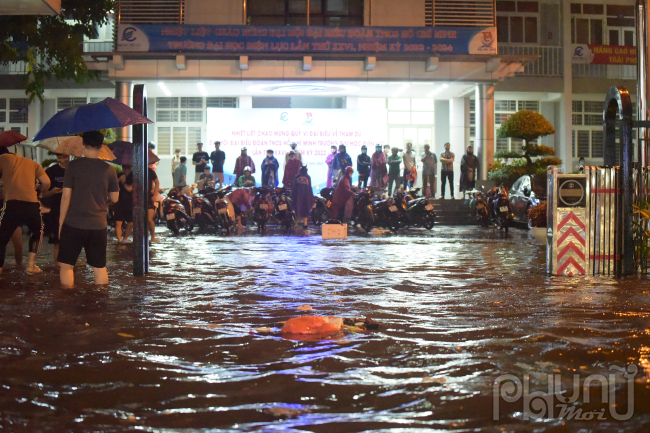 Người dân trú mưa tại Đại học Điện lực.