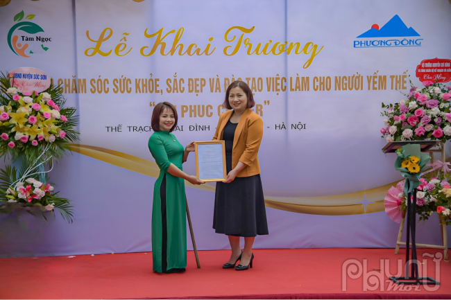 Bà Lê Thị Tường Thu, chủ tịch công đoàn bộ Kế Hoạch và Đầu tư, trao phần quà là 100 triệu đồng cho trung tâm.