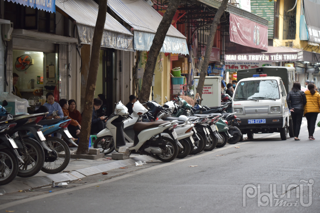 Cửa hàng kinh doanh đồ uống giải khát để xe lấn chiếm vỉa hè ngay cạnh Công an phường Hàng Đào trong khi xe của lực lượng chức năng phường để ngay cạnh.