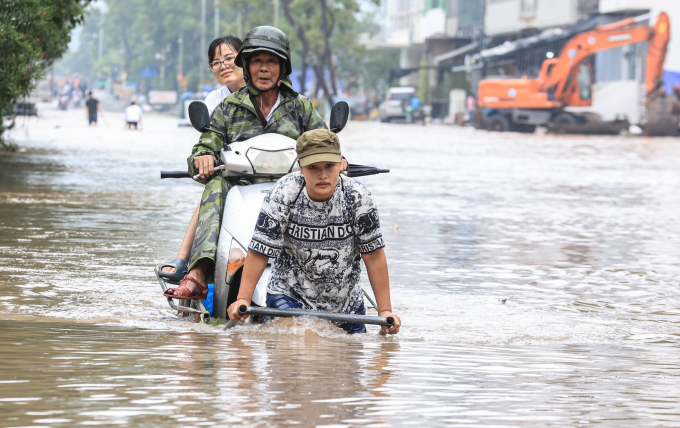 Nhiều khu vực ngập sâu người dân phải dùng xe kéo chở xe máy với người: Ảnh BGT