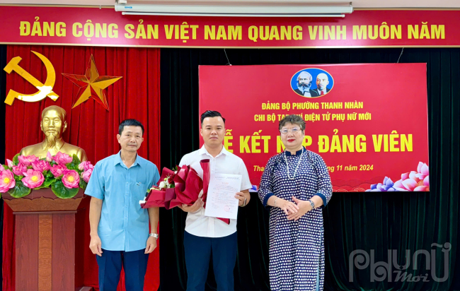 Đồng chí Phạm Thanh Hà - Bí thư chi bộ tạp chí điện tử Phụ nữ Mới cùng đồng chí Phùng Đức Thọ - Phó Bí thư Đảng ủy phường Thanh Nhàn trao quyết định kết nạp đảng viên tặng hoa chúc mừng dồng chí Hoàng Văn Toàn.