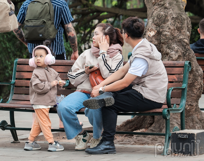 Trẻ em được bố mẹ mặc thêm áo khoác ấm, bịt tai đảm bảo sức khoẻ trong đợt lạnh