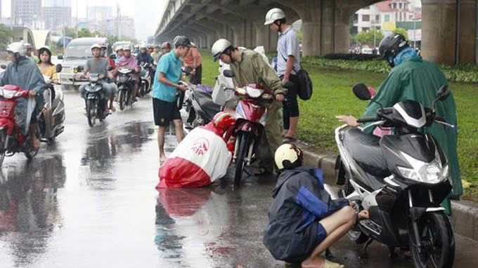 Dừng xe mặc áo mưa trên đường khi tham gia giao thông. Nguồn ảnh: ITN