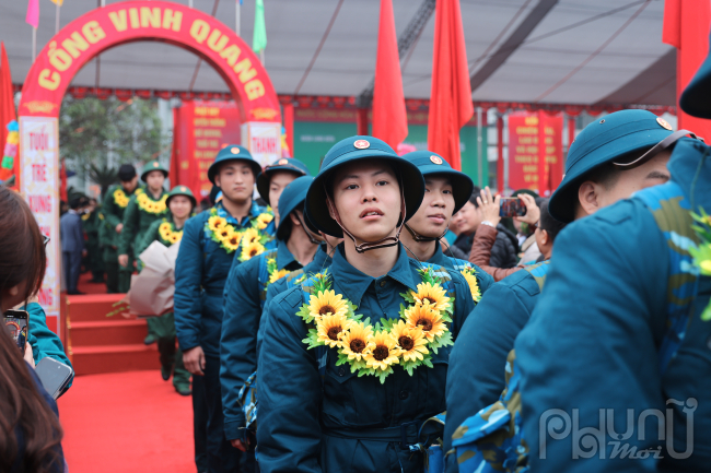 Trong không khí náo nhiệt, tiếng nói cười lẫn với tiếng còi xe, chỉ có ánh mắt tân binh là tĩnh lặng. Cậu nhìn xa xăm, hướng về phía người đám đông tìm người thân trước lúc lên xe về đơn vị.