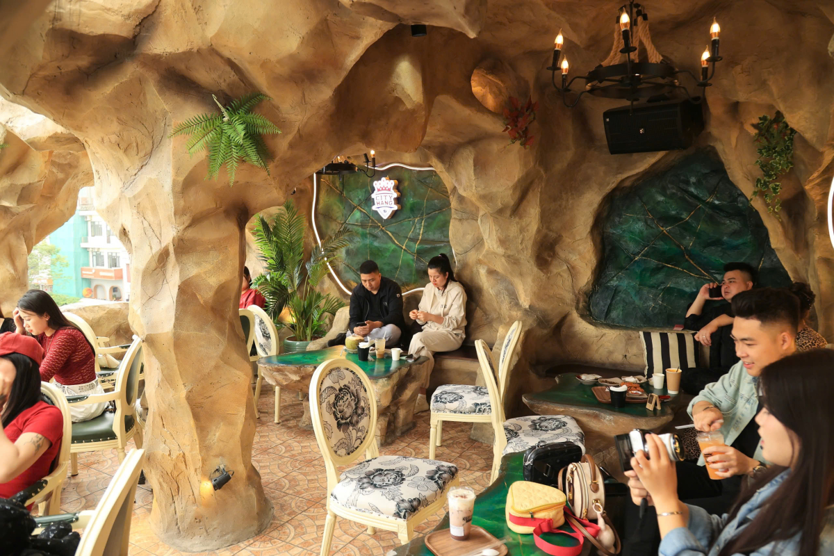 Giữa lòng thành phố náo nhiệt, quán cà phê ẩn mình như một hang động thực sự, nơi những khối đá sừng sững tạo nên một không gian yên bình và tĩnh lặng.