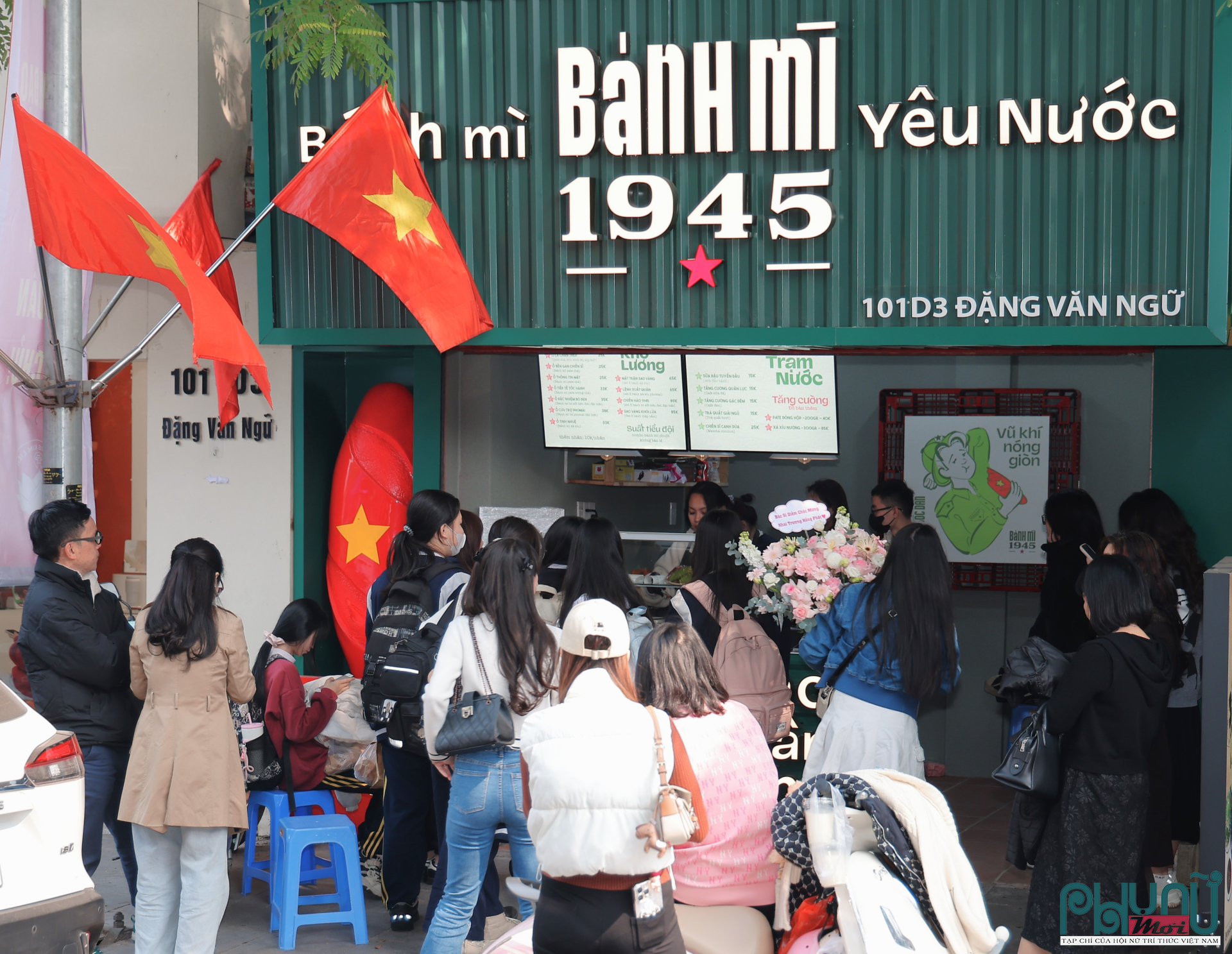Tiệm bánh mì chật kín khách ngay trong ngày khai trương, nhiều người xếp hàng chờ mua và trải nghiệm sản phẩm mới. Không khí tại cửa hàng luôn nhộn nhịp, nhân viên làm việc liên tục để kịp phục vụ lượng khách tăng cao, tạo nên một điểm dừng chân ẩm thực sôi động giữa khu phố.
