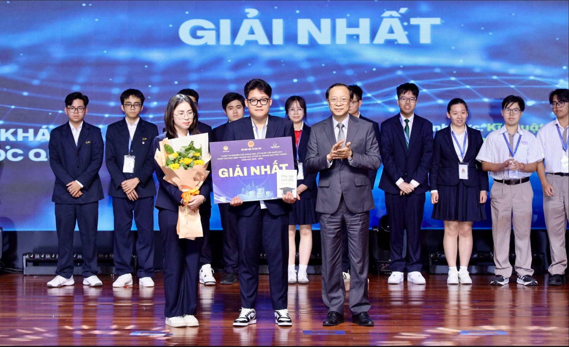 Thứ trưởng Thường trực Bộ Giáo dục và Đào tạo Phạm Ngọc Thưởng trao giải Nhất cho các học sinh đạt giải. Ảnh: BTC