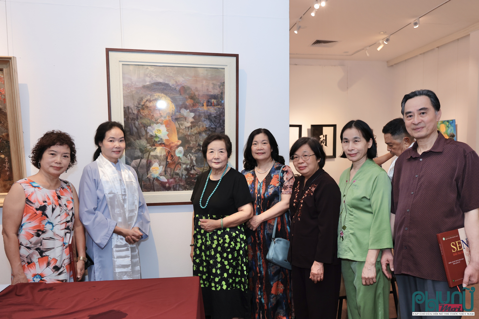 Họa sĩ Trần Thanh Thục (thứ hai từ trái sang) chụp ảnh lưu niệm cùng khách mời tham quan triển lãm bên tác phẩm “Thành - trụ - hoại - không”.