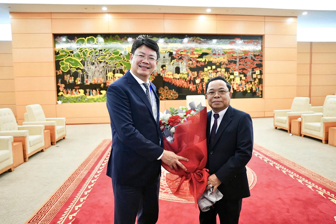 Thứ trưởng Bộ Tư pháp Nguyễn Thanh Tịnh tặng hoa chào mừng Ủy viên Bộ Chính trị, Phó Thủ tướng Chính phủ, Bộ trưởng Bộ Tư pháp Lào Khăm-phăn Phôm-ma-thắt.