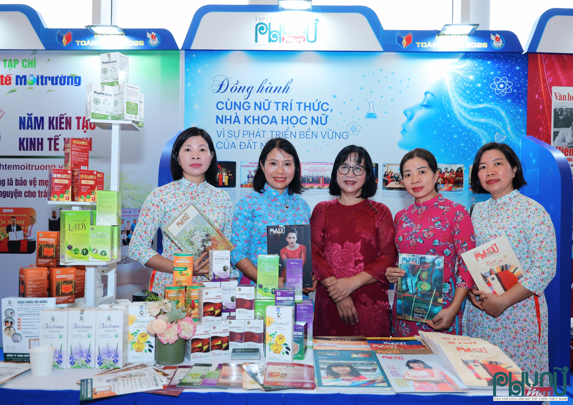 Hai nhà khoa học thuộc Viện Hàn lâm Khoa học và Công nghệ Việt Nam là TS. Bà Thị Châm (thứ hai từ phải sang), công tác tại Viện Hóa học, và TS. Nguyễn Thị Thúy Hường (áo xanh, thứ hai từ trái sang), công tác tại Viện Sinh học, tham gia giao lưu tại gian trưng bày của Tạp chí Phụ nữ Mới.