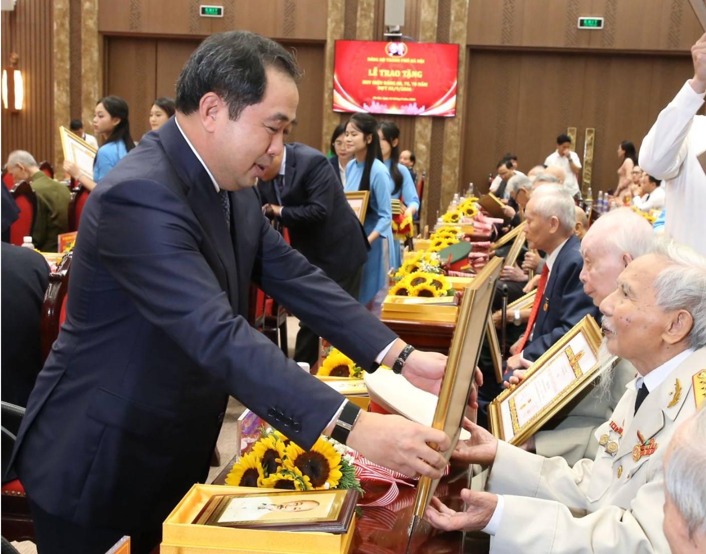 Đồng chí Trần Đức Thắng, Ủy viên Bộ Chính trị, Bí thư Thành ủy Hà Nội trao Huy hiệu Đảng tặng đảng viên lão thành.