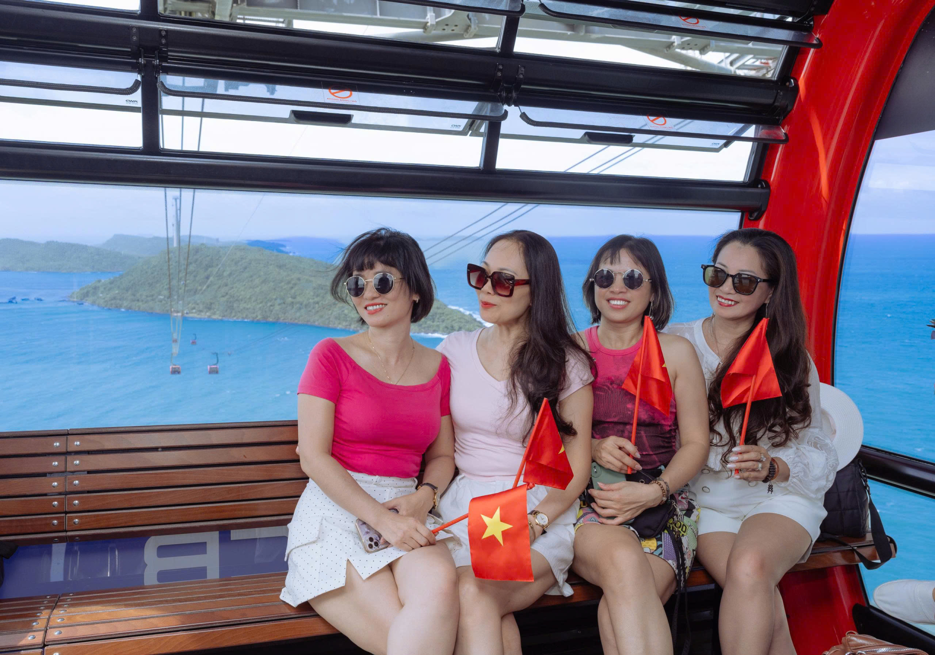 Từ Thị trấn Hoàng Hôn, hành trình tiếp tục trên tuyến cáp treo ba dây vượt biển tới đảo Hòn Thơm. Từ ga cáp treo đến khu vui chơi, nhiều không gian được trang hoàng cờ hoa, trở thành điểm chụp ảnh được du khách yêu thích.