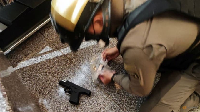 Một sĩ quan cảnh sát thu súng tại trung tâm mua sắm Siam Paragon, ở Bangkok, Thái Lan, ngày 3 tháng 10.