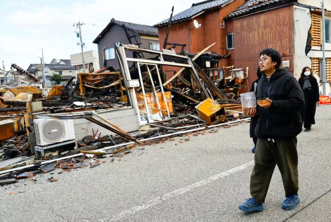 Kohei Kirimoto, 31 tuổi, cầm trên tay thức ăn cho mèo, đi loanh quanh đống đổ nát tìm những con mèo bị thất lạc sau trận động đất.