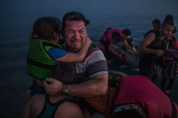 Ngày 15 tháng 8 năm 2015. Laith Majid, người Iraq, bật khóc vì sung sướng, bế con trai và con gái sau khi họ đến Kos, Hy Lạp, trên một chiếc thuyền cao su mỏng manh.  (Ảnh của Daniel Etter)