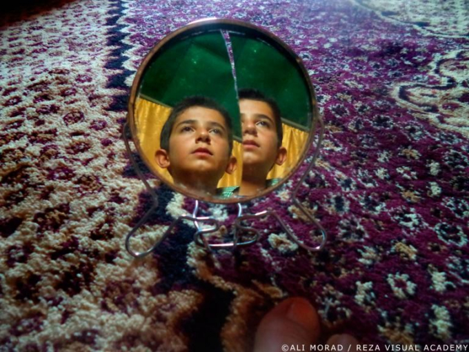 Cậu bé 11 tuổi Ali Morad với bức chân dung tự chụp qua một chiếc gương vỡ. (Nguồn: nationalgeographic.com)