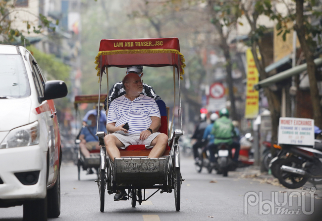 Du khách nước ngoài không đeo khẩu trang khi tham quan đường phố Hà Nội