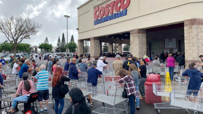   Nhiều người xếp hàng dài ở siêu thị Costco chờ mua hàng. Ảnh: Reuters  