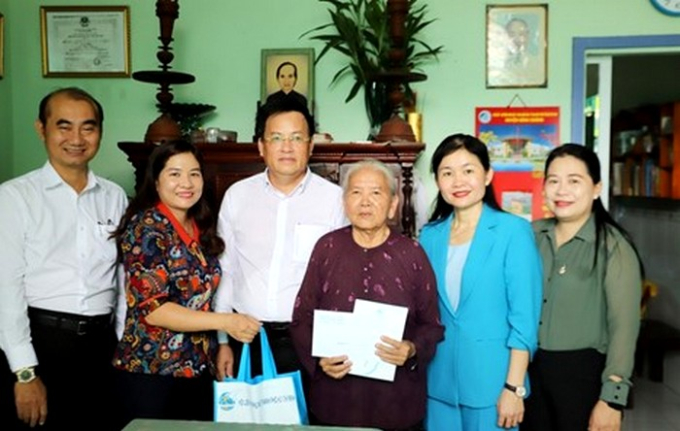 Phó Chủ tịch Hội LHPN Việt Nam Tôn Thị Hạnh (thứ hai, từ phải qua) cùng bà Nguyễn Thị Ngọc Linh (thứ hai từ trái qua) - Phó chủ tịch Hội LHPN TPHCM cùng đại diện lãnh đạo huyện Bình Chánh tặng quà dì Ca Thị Hạnh.